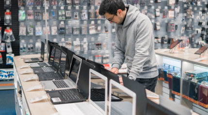 modern male customer choosing laptop in the computer store