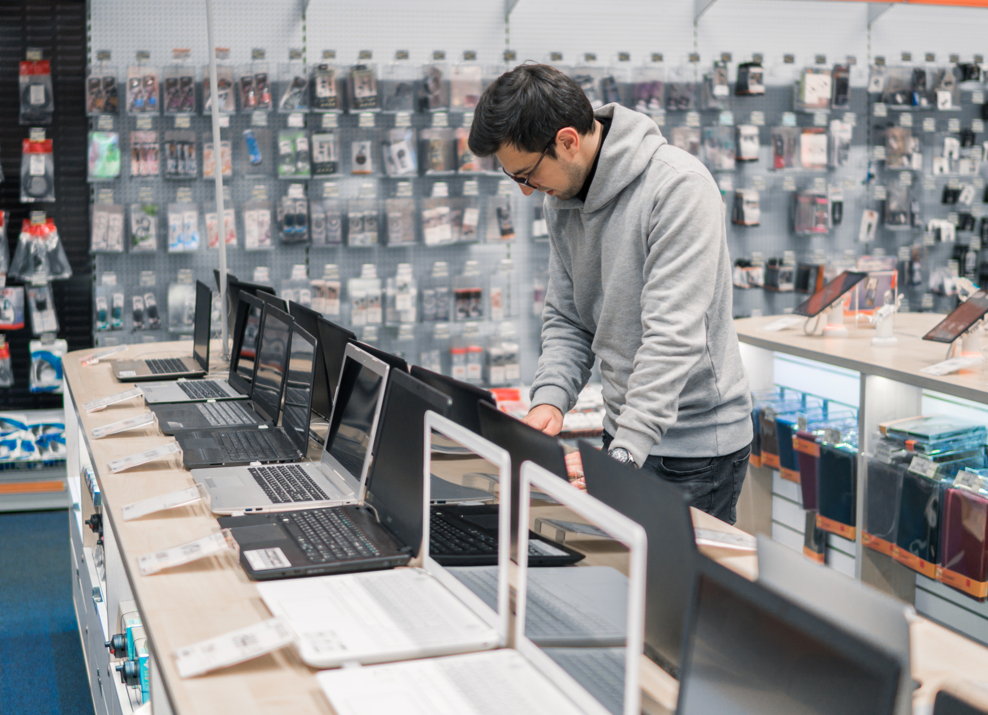 modern male customer choosing laptop in the computer store